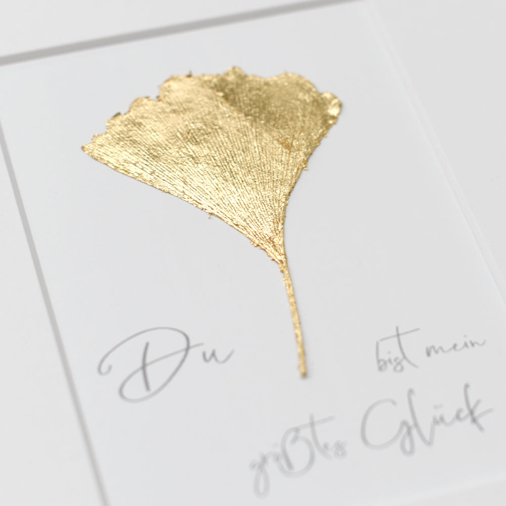 Echtes vergoldetes Ginkgoblatt mit Sprch, vergoldet mit 23,5 Karat Echtgold. Text: "Du bist mein größtes Glück"